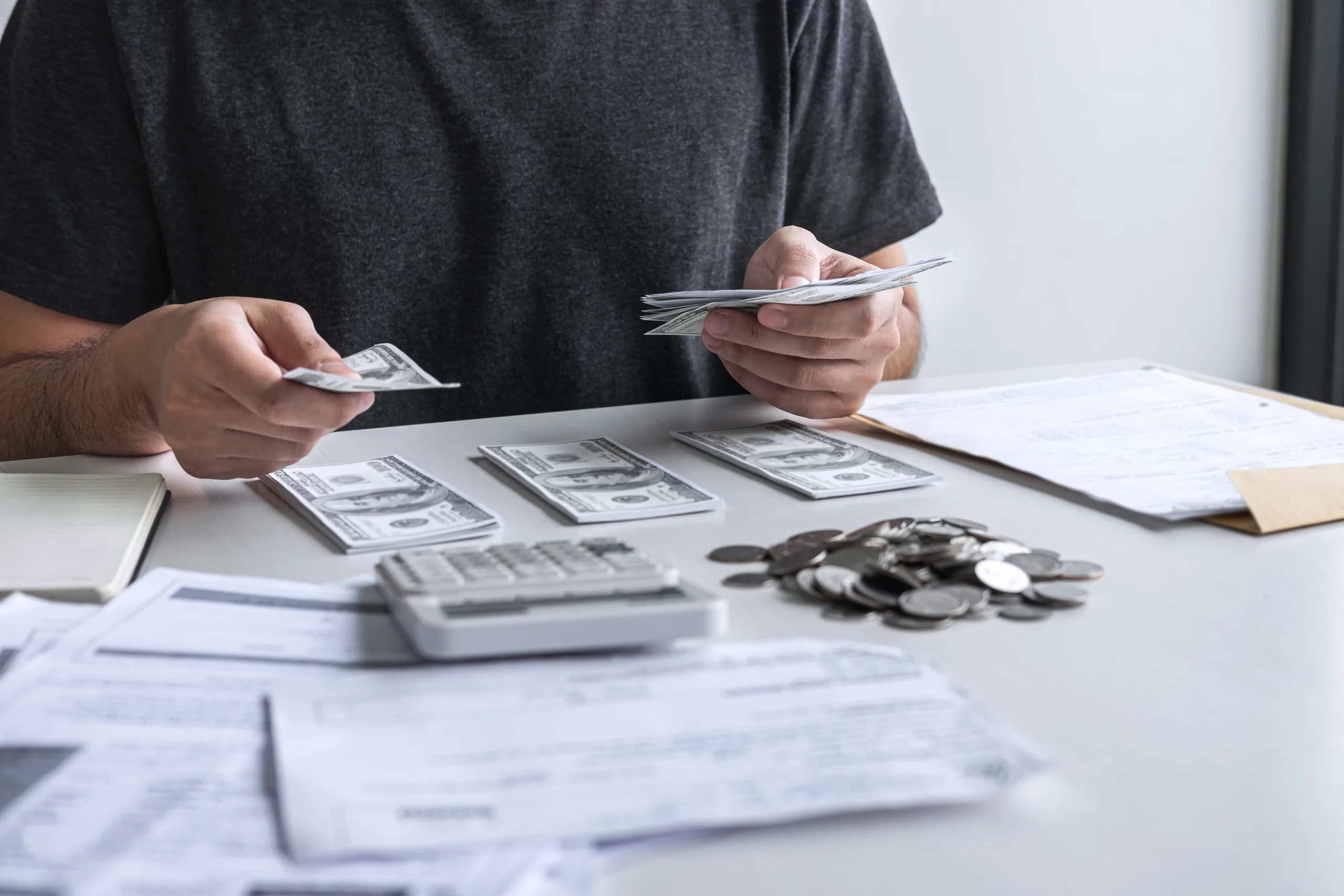 Person counting cash with calculator and papers symbolizing Missouri medical debt bankruptcy