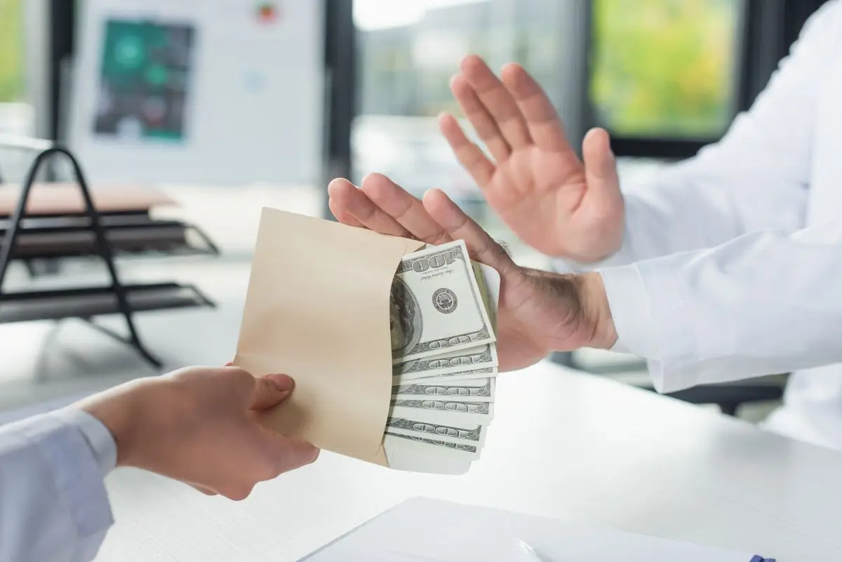 Person refusing an envelope filled with cash, symbolizing stopping wage garnishment and financial relief through bankruptcy in Missouri.